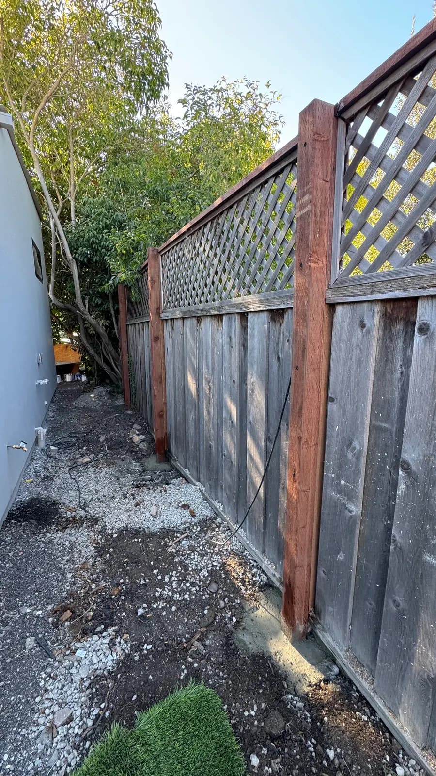 The same fence line after the posts were replaced — the original boards were kept